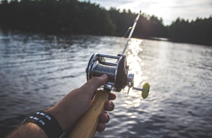Fishing - person holding black and silver fishing reel