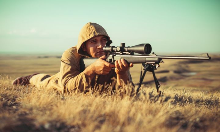 Hunting - man in brown jacket holding black rifle